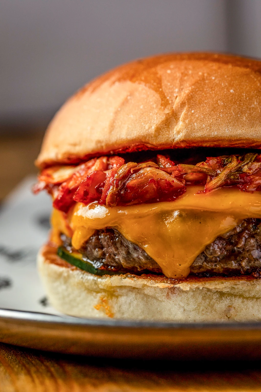 Close-up of a burger with melted cheddar and kimchi