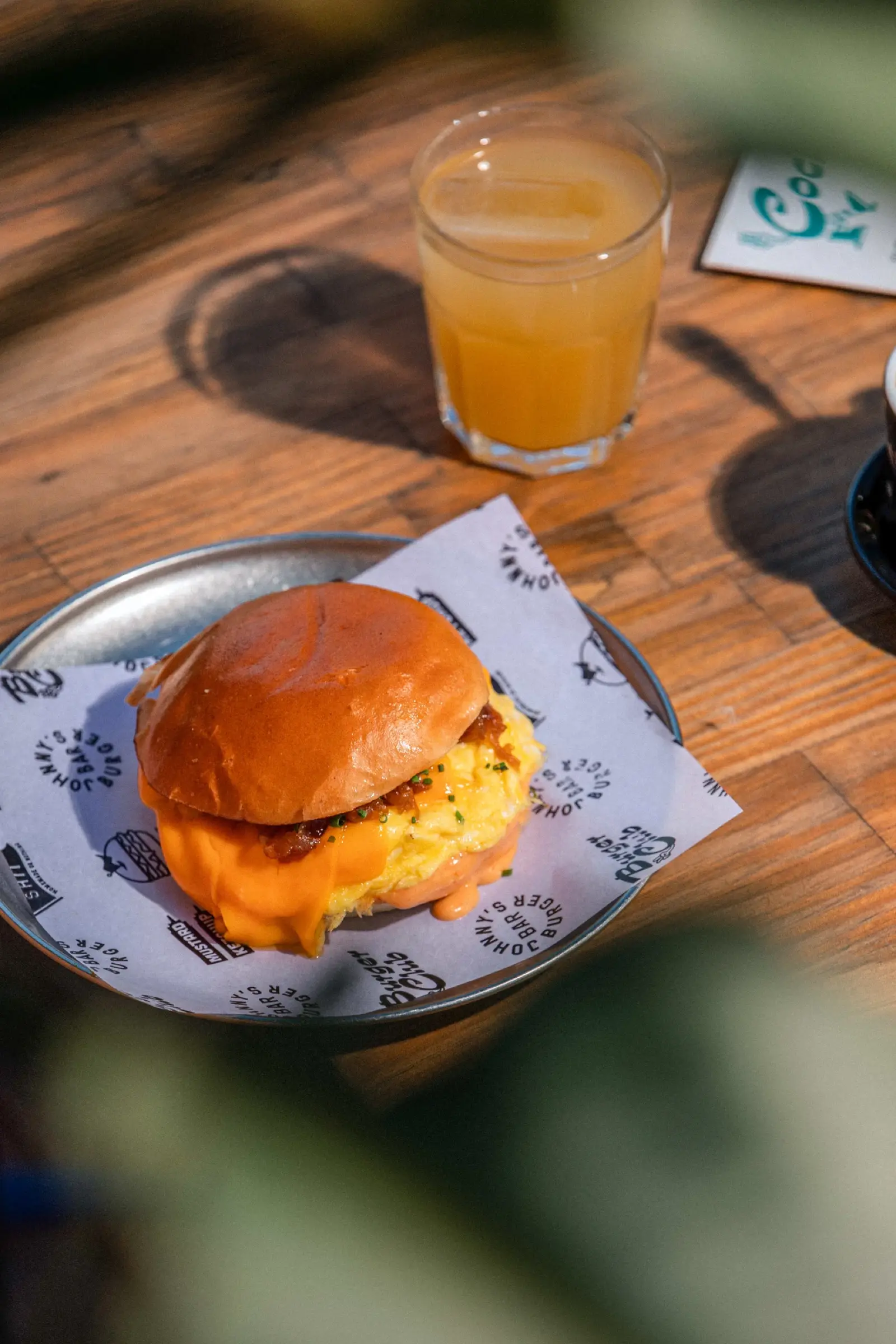 Brunch scrambled egg bun with cheddar and bacon, with orange juice