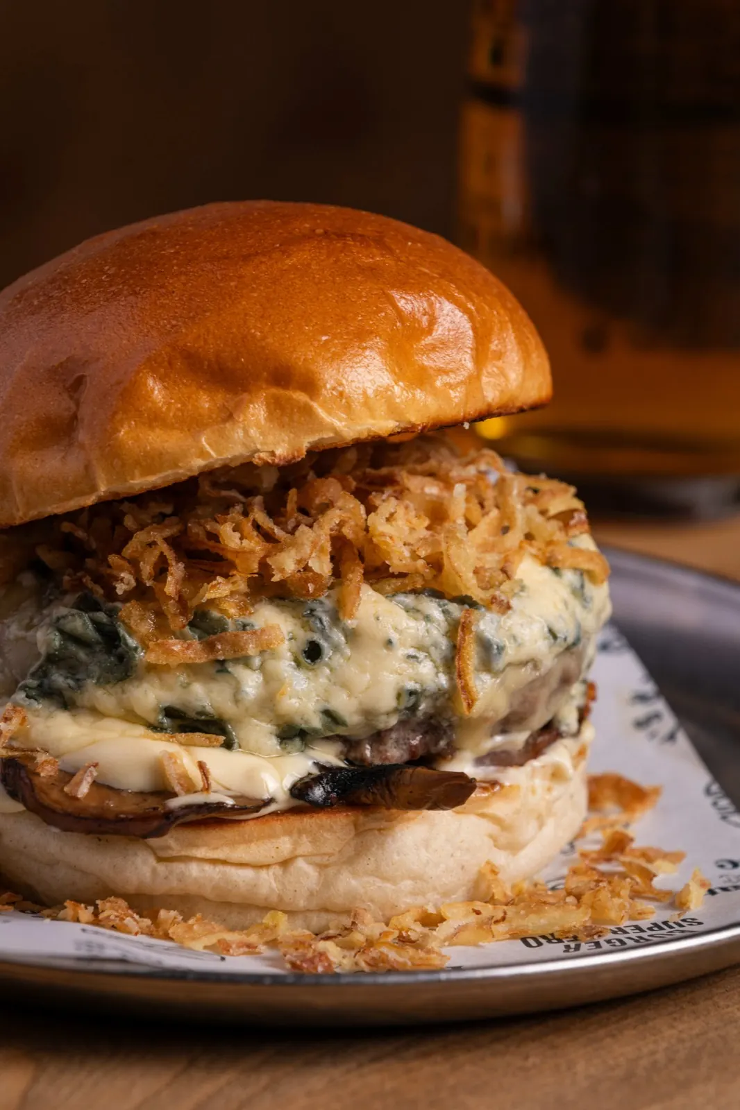 Burger with melted cheese, crispy onion and mushrooms
